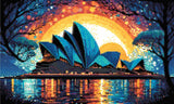A Diamond Painting Rendering Of Sydney Opera House Against A Vibrant Sunset Sky With Hues Of Orange, Blue, And Purple, Reflecting On The Water Below. Size - 50cm X 30cm