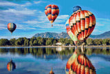 colourful hot air balloons reflecting on a lake with mountains in the background. Size - 90cm x 60cm