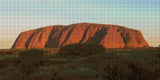 Uluru at sunset with glowing red hues and surrounding greenery. Size - 80cm x 40cm