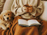Person holding a mug with a puppy and an open book on a blanket. Size - 40cm x 30cm