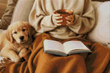 Person holding a mug with a puppy and an open book on a blanket. Size - 60cm x 40cm