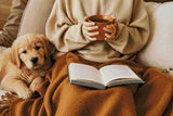 Person holding a mug with a puppy and an open book on a blanket. Size - 90cm x 60cm